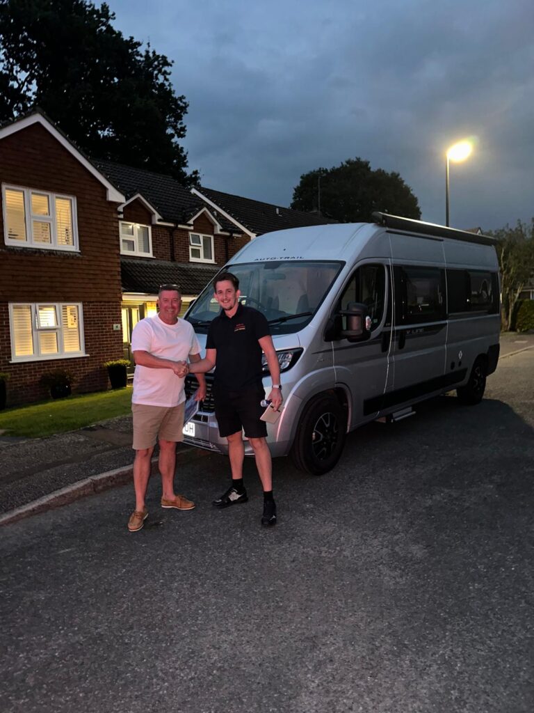 Two men shaking hands by caravan sell my caravan fast