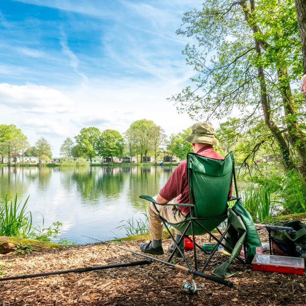 Two anglers by serene lake.
