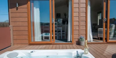 Hot tub beside modern lodge entrance.